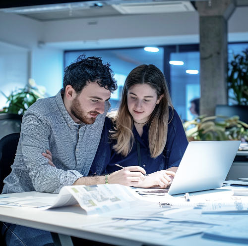 Zwei Architekten arbeiten im Büro an einem Projekt, unterstützt von Sacred Byte Infrastruktur